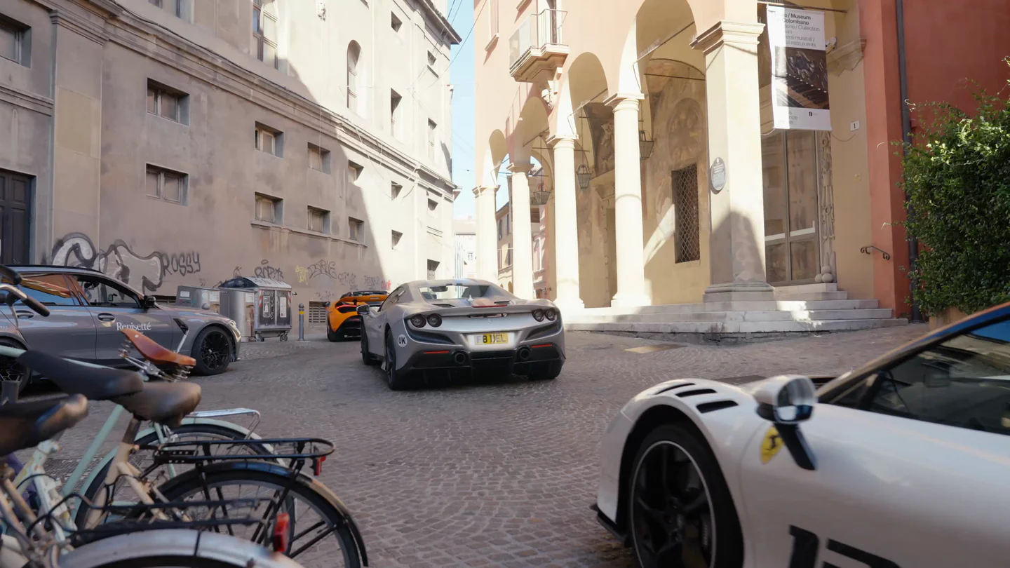 Supercars parked in a historic town square on a Renisetté tour